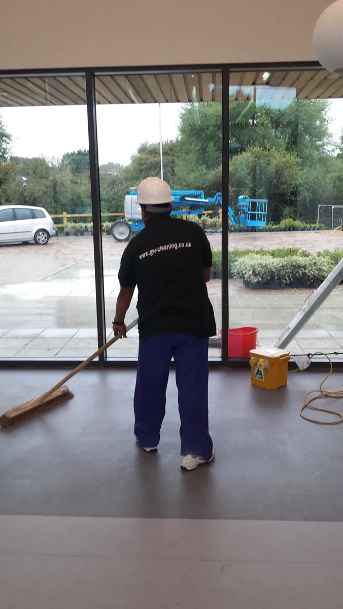 GW Cleaning operative in a branded shirt working in a glazed unit